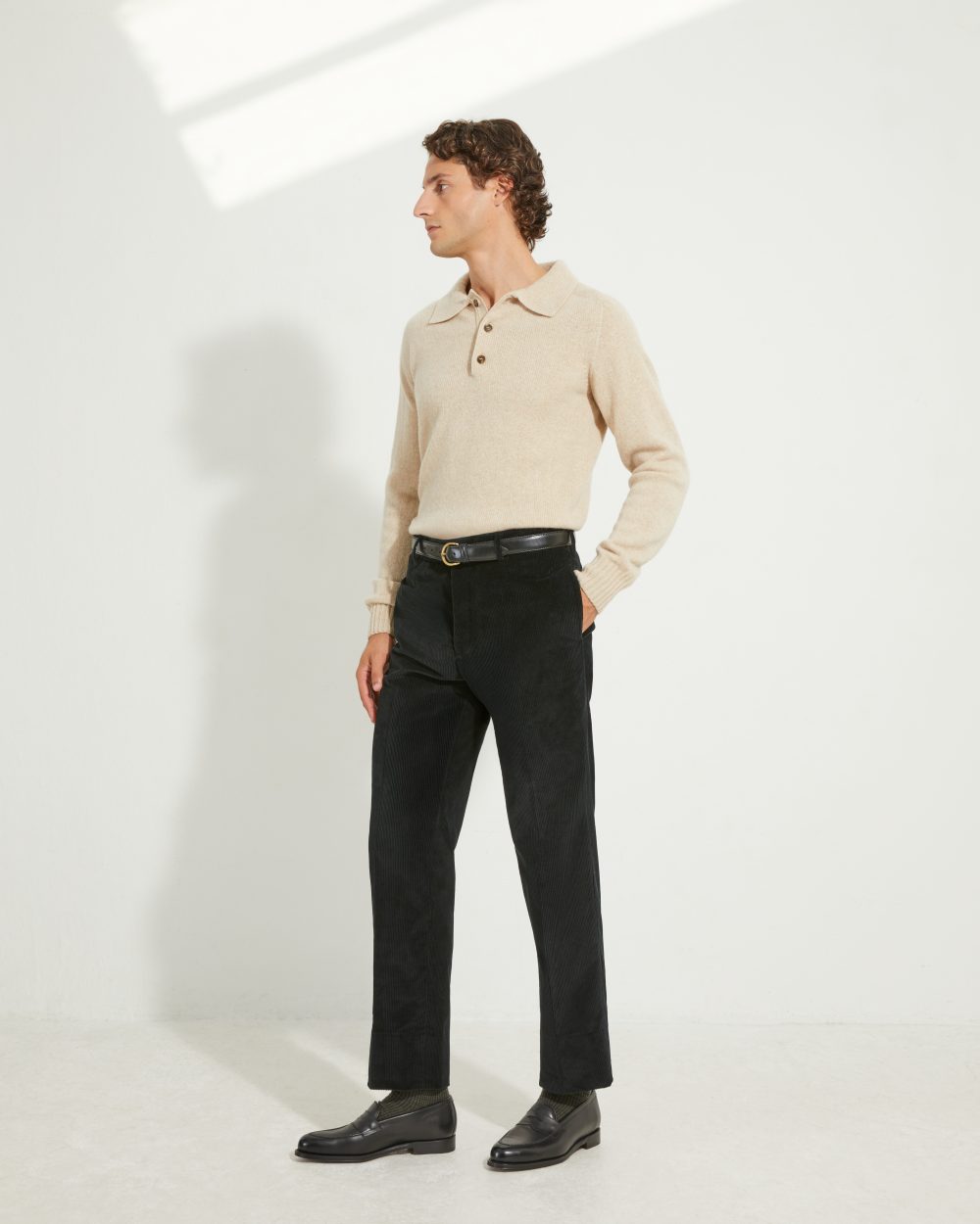 Look complet Scavini avec pantalon coupe classique en velours côtelé noir, polo en laine beige tricoté en Écosse et mocassins Nicodème Septième Largeur noirs.