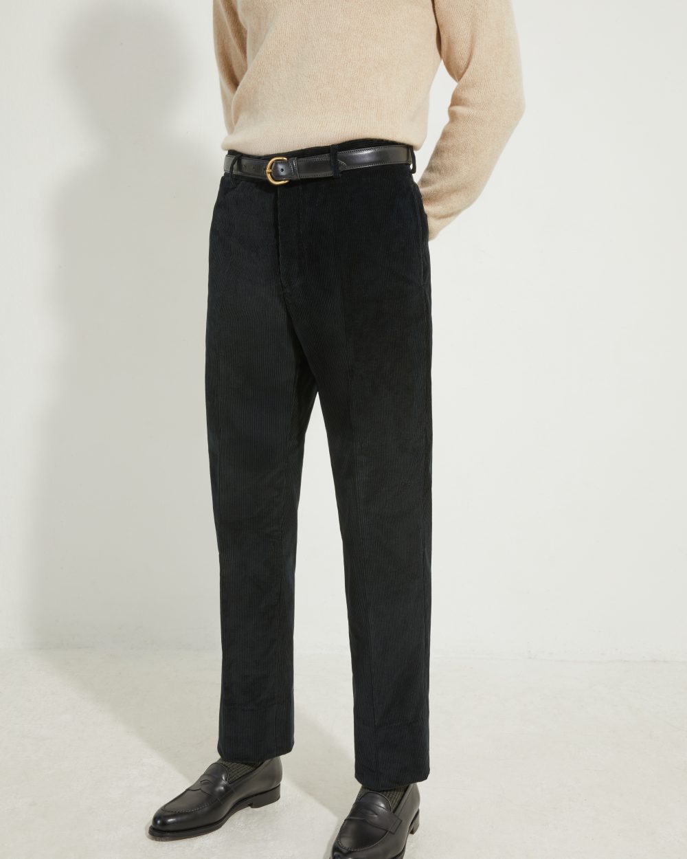 Vue de face du pantalon coupe classique en velours côtelé noir Scavini, porté avec une ceinture en cuir noir.