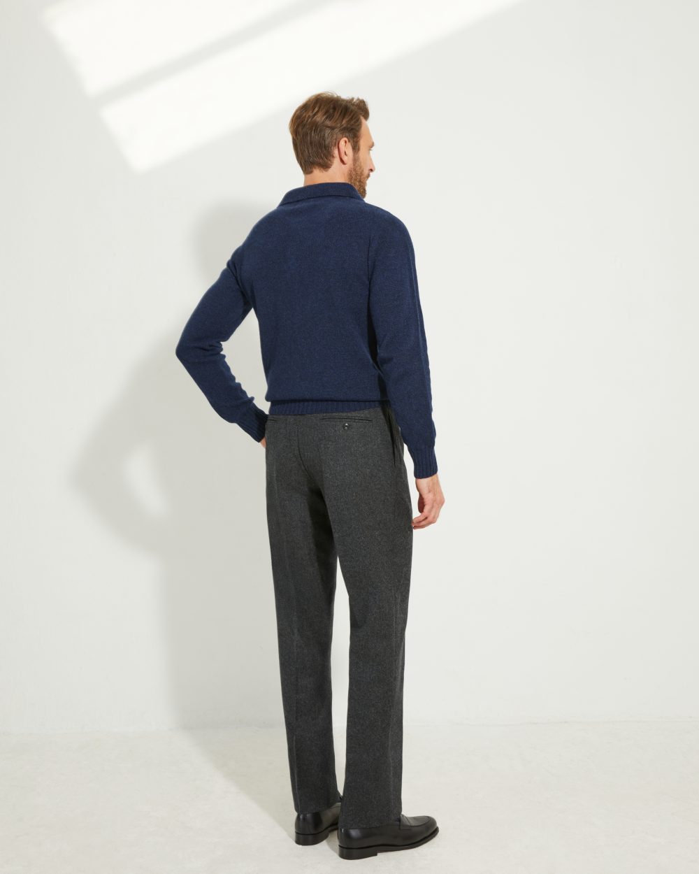 Vue de dos du pantalon en flanelle anthracite Scavini porté avec un polo en laine.