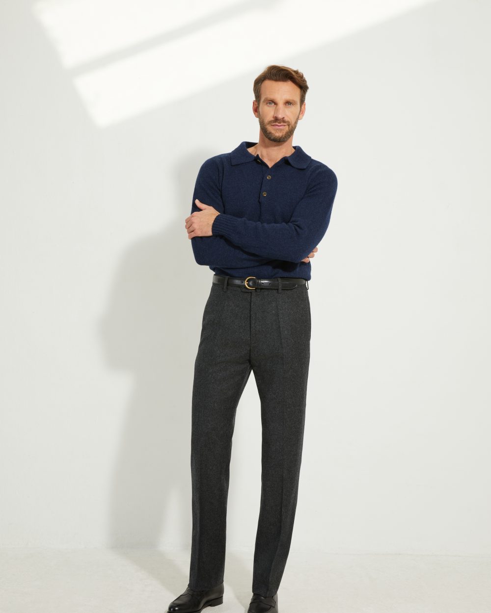 Pantalon en flanelle anthracite Scavini porté avec un polo en laine bleu marine.