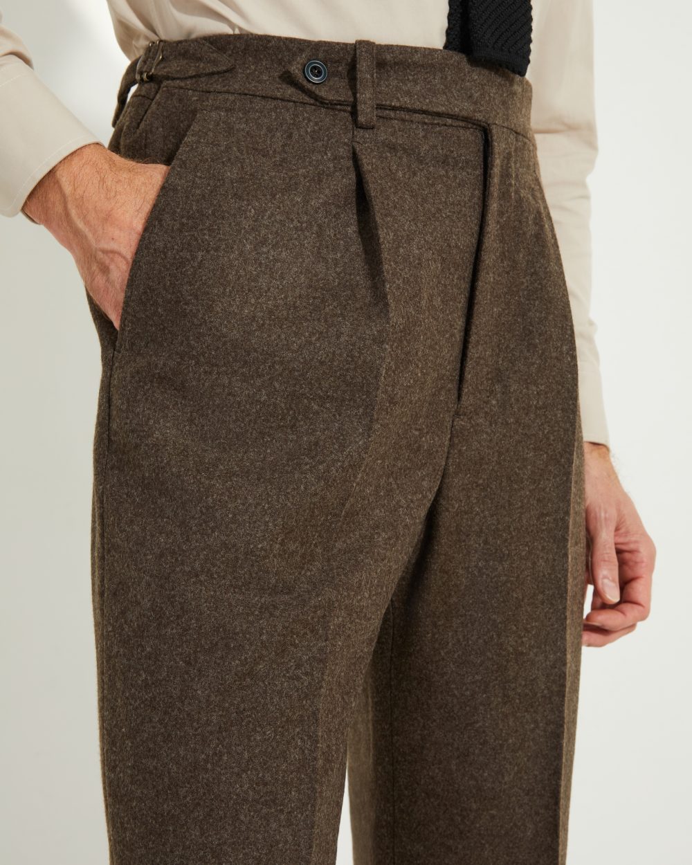 Détail des pinces avant et des ajusteurs latéraux du pantalon en flanelle marron Scavini.