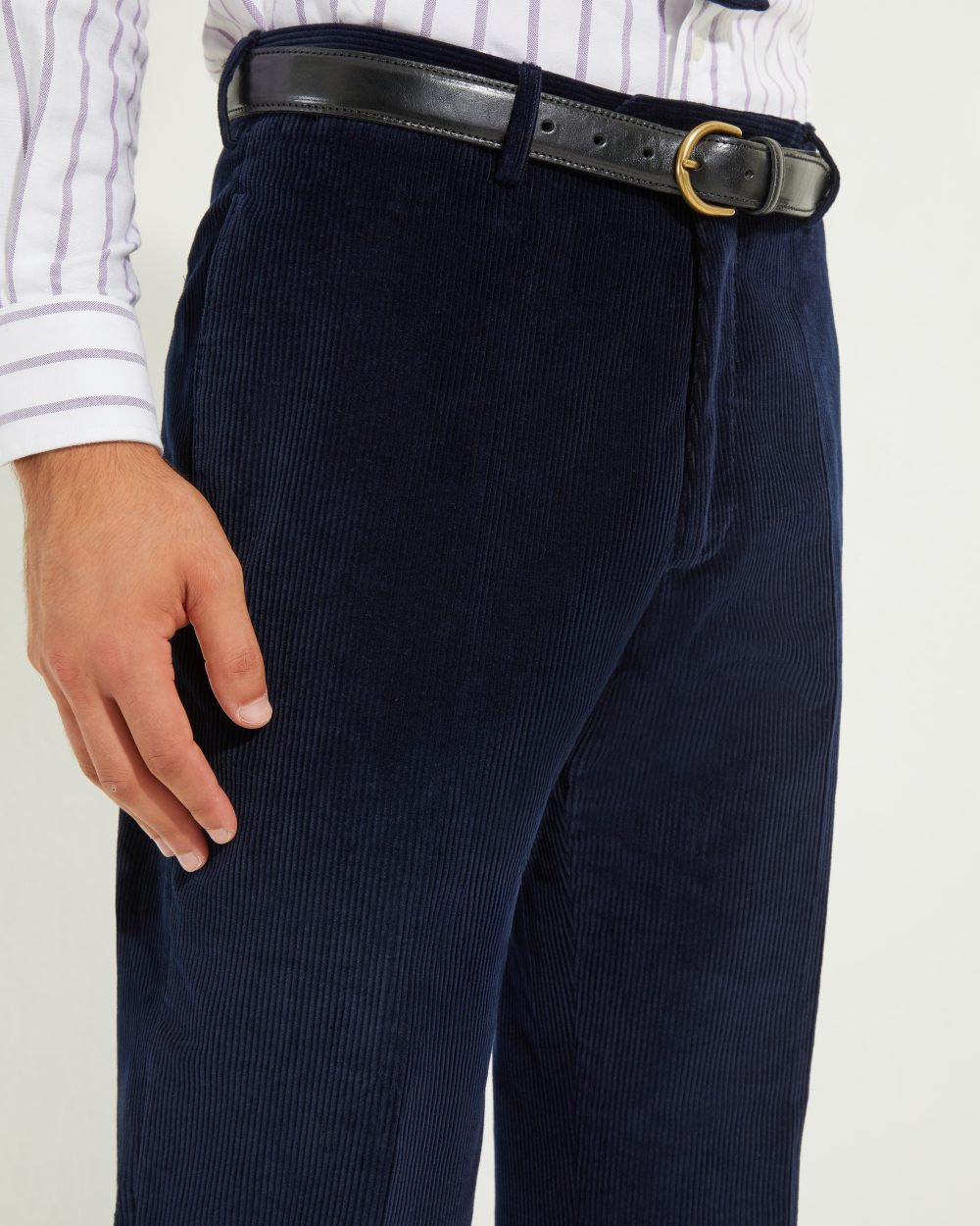 Détail des passants de ceinture du pantalon coupe classique en velours côtelé marine Scavini, porté avec ceinture en cuir noir.