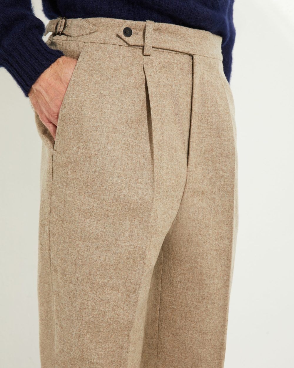 Détail pince avant et ajusteurs latéraux du pantalon en flanelle beige Scavini.