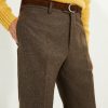 Pantalon en flanelle marron Scavini, coupe classique, porté avec veste et pull.