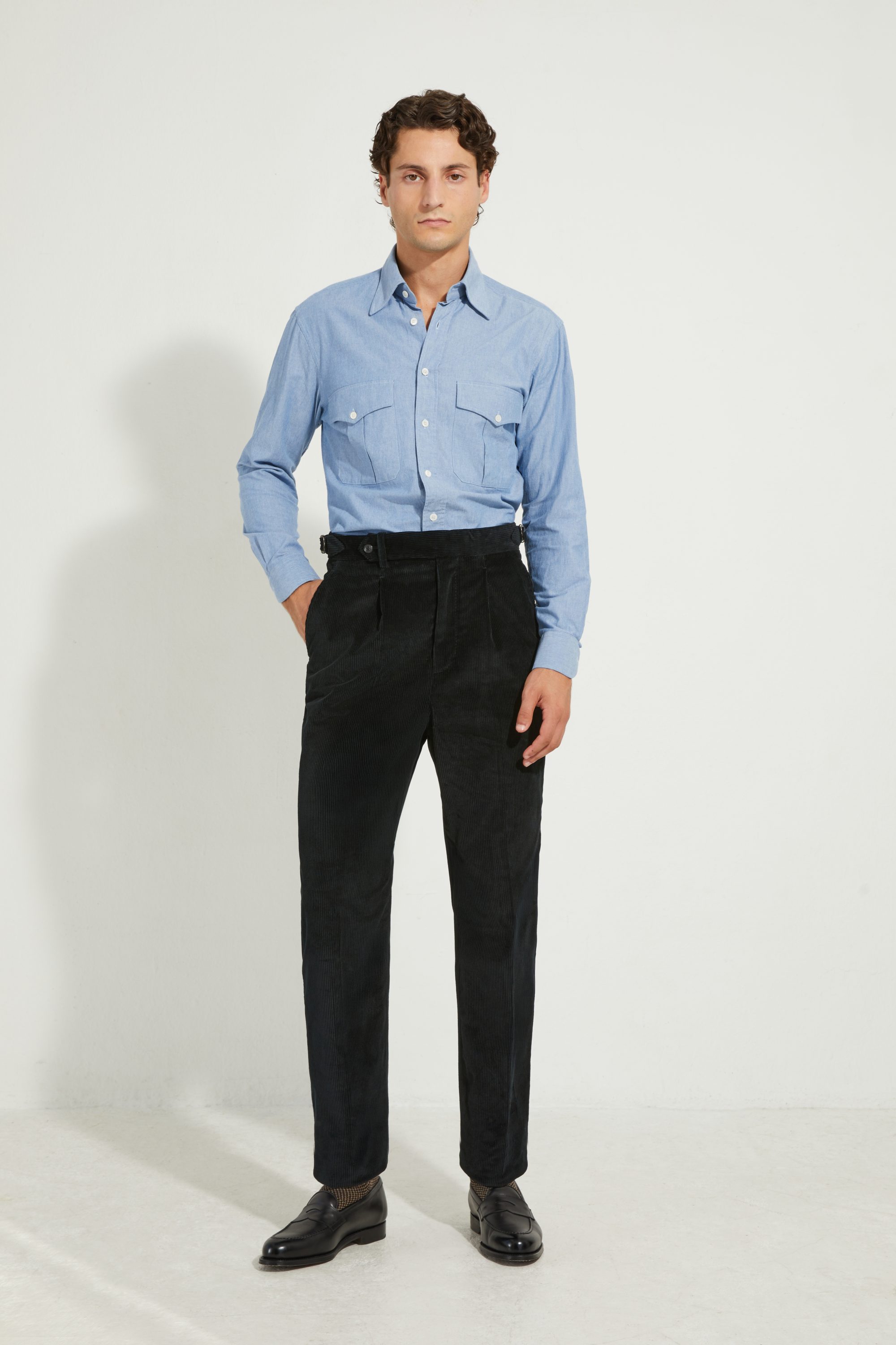 Pantalon en velours côtelé noir Scavini porté avec une chemise en chambray.