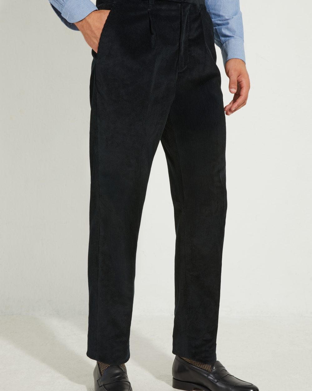 Pantalon en velours côtelé noir Scavini, main dans la poche.