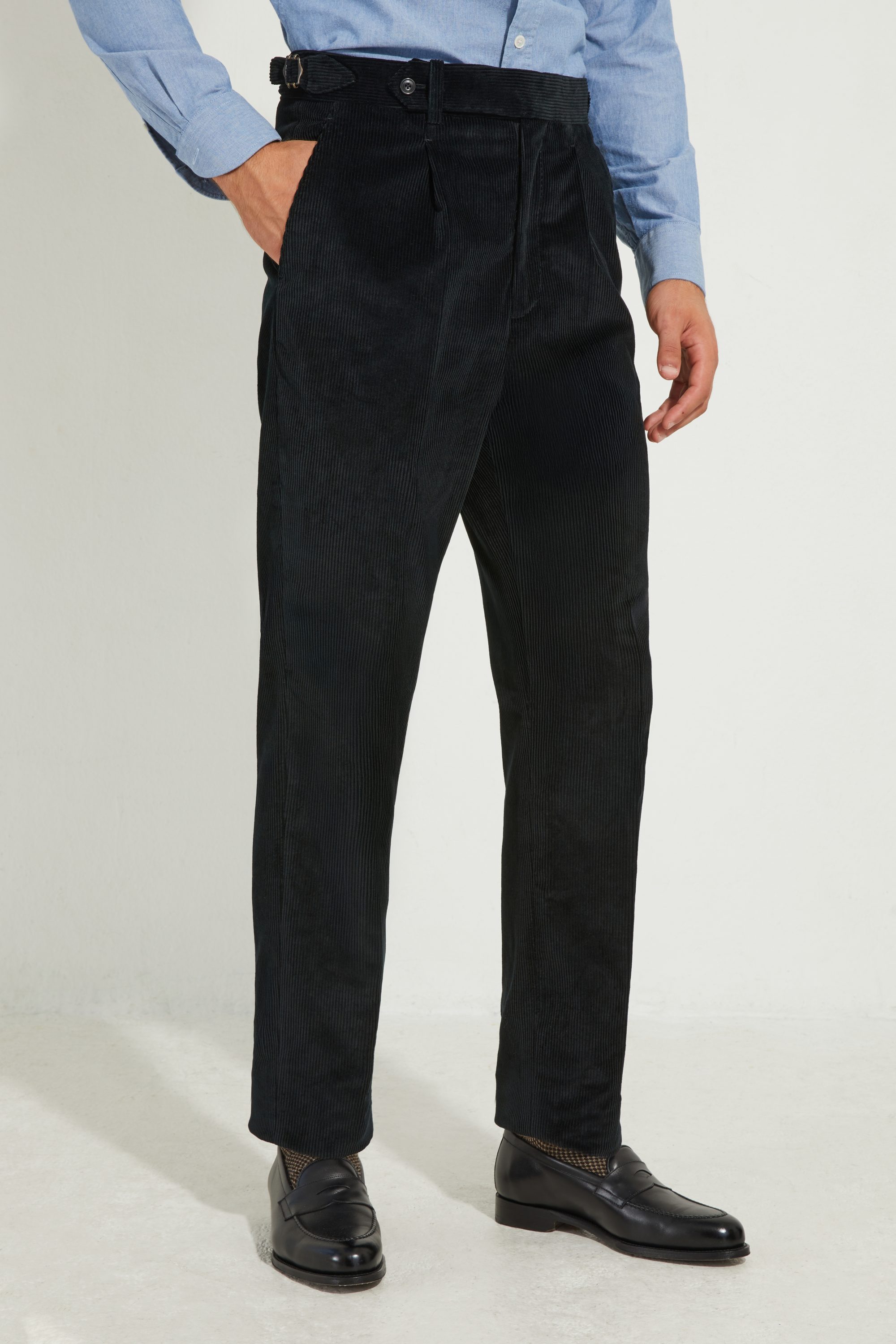 Pantalon en velours côtelé noir Scavini, main dans la poche.