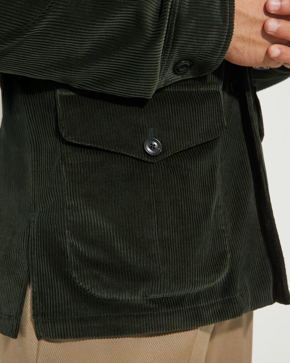 Détail de poche à rabat de la veste Faubourg Scavini en velours côtelé vert, bouton en corne.
