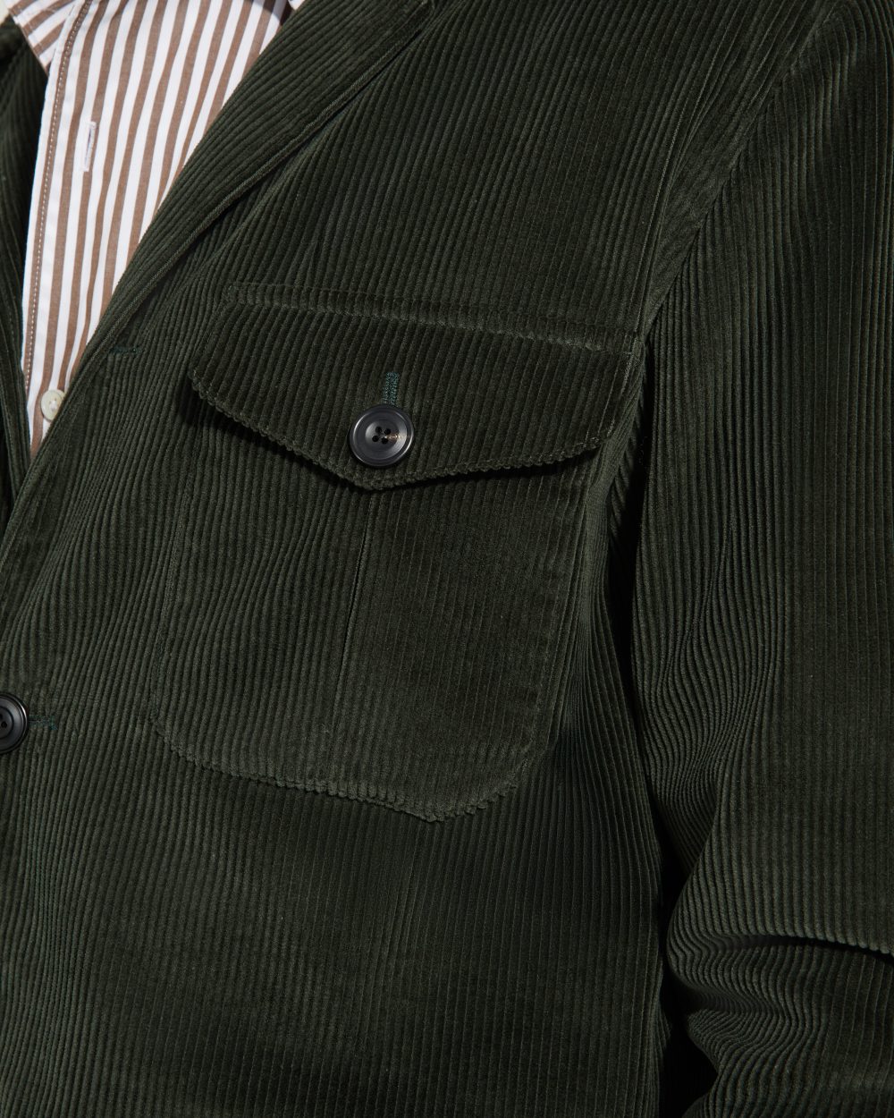 Détail de la poche poitrine à rabat de la veste Faubourg Scavini en velours vert, bouton en corne.