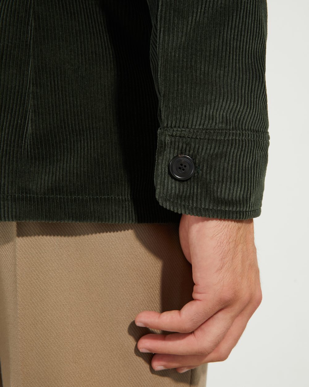 Détail du poignet de la veste Faubourg Scavini en velours côtelé vert, avec bouton en corne.